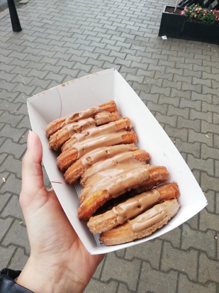 Churrosy polane sosem karmelowym w papierowej tacce